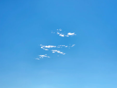 A bright blue sky with small patches of white cirrus clouds