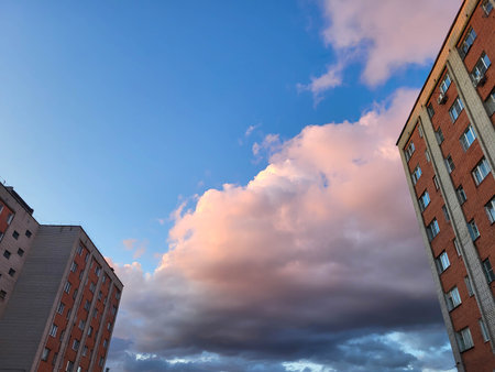 At sunset, delicate pink clouds in the sky between the houses.の写真素材
