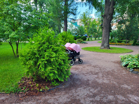 Walking through a springtime green park with a pink stroller for twins