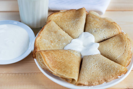 Pancakes with sour cream and milk on the tableの写真素材