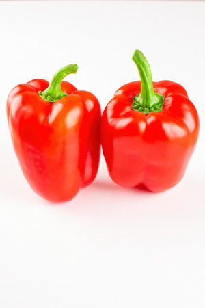 Two red bell peppers on a white background.の写真素材