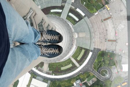 Small man in high tower with transparent floorの写真素材