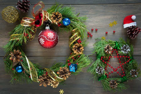 Christmas Pine with cones, ribbons, and Golden nuts on a wooden background. Flat position style. Holiday decoration.の写真素材