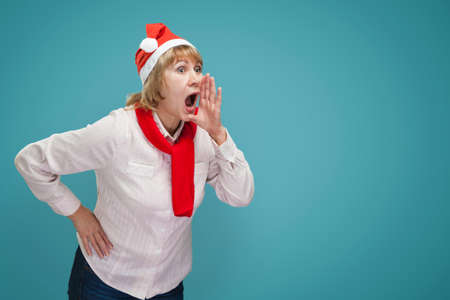 Shows a screaming woman. A middle-aged woman in the new year and Christmas clothes on a blue...