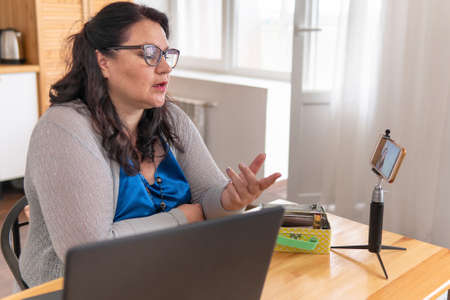 A woman blogs on her smartphone. She's on the phone. Business in social networks.の写真素材