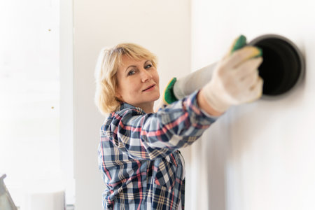 Female construction worker with a plastic pipe. Middle-aged woman doing repairs in the house.の写真素材