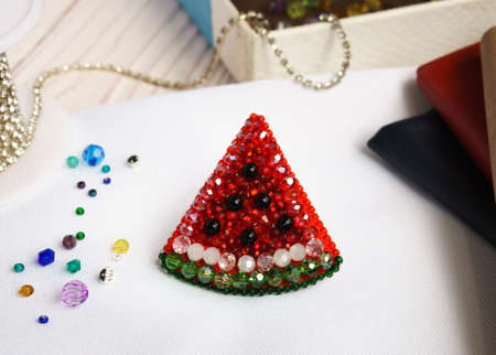 Handmade beaded watermelon red on table on white background