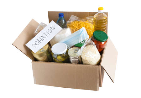 Cardboard box with oil, canned food, cereals and pasta. Donation box with various food. Isolatedの写真素材