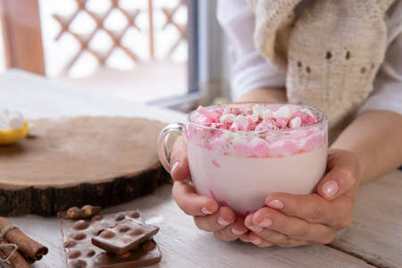 Hot drink with marshmallows on a wooden table.