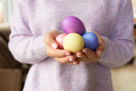 A woman holds a traditional Easter cake on the table.の写真素材