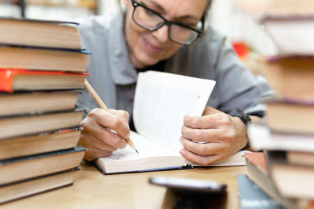woman in the library in front of bookshelves. Concept of educationの写真素材