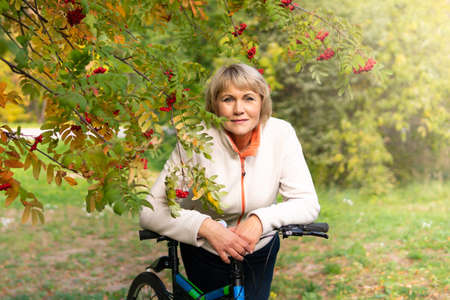 A woman on a Bicycle rides on the road in the city Parkの写真素材