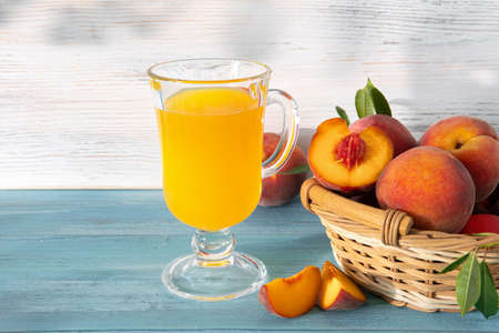 Sweet ripe juicy peaches with green leaves on a wooden backgroundの写真素材