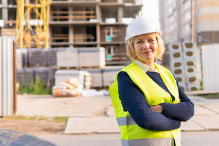 A woman Builder at a construction site inspects a buildingの写真素材