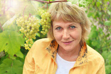 Woman in kitchen garden harvests fruits and vegetablesの写真素材