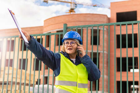 A woman Builder at a construction site inspects a buildingの写真素材