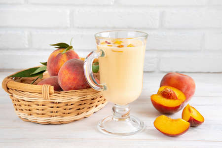 Sweet ripe juicy peaches with green leaves on a wooden backgroundの写真素材