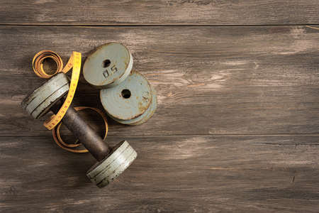 Dumbbells on white wooden background, fitness and health concept.