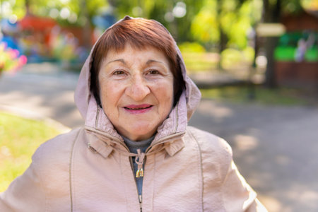 An elderly woman walks nordic with sticks in the Park on a Sunny summer day