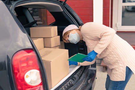 Woman Courier delivers cargo to the address by car