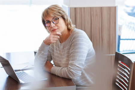 A woman in a cafe working on a laptop. The concept of business and remote work.