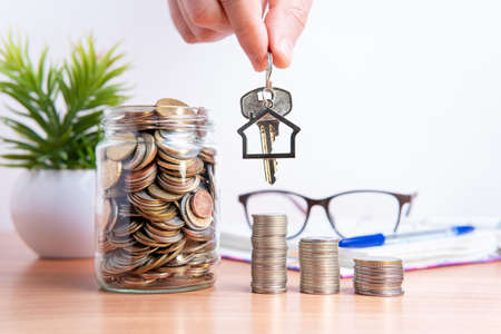 Coins in a glass jar. Accumulation of capital. A loan to buy a house. Mortgage.の写真素材