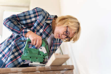 Woman Builder in the room of the house making repairs.