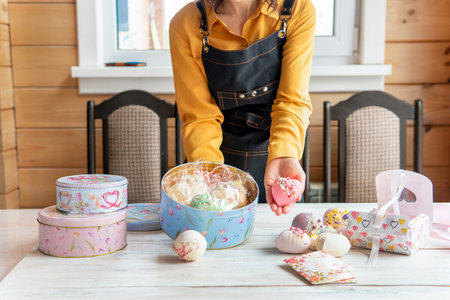 A woman holds a gift box with a bow at the table.