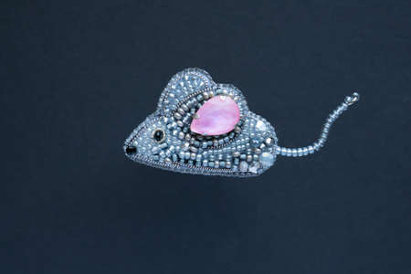 Brooch handmade made of multicolored beads on the background