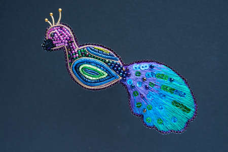 Brooch handmade made of multicolored beads on the backgroundの写真素材