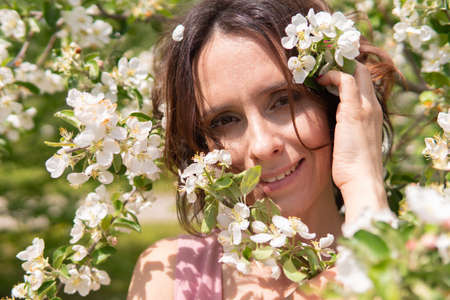 A woman near a blooming spring tree. Romantic happy mood.