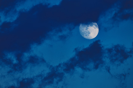 Moon in the cloudy blue summer skyの写真素材