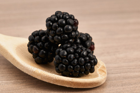 blackberries on a wooden spoon horizontallyの写真素材