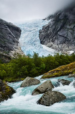 Beautiful Norwegian landscape with glacier River and treesの写真素材
