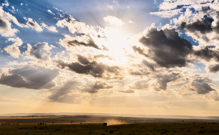 Off-road car during a safari in Kenya under a beautiful sky full of clouds.の写真素材