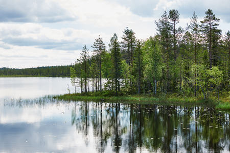 Relaxing Finnish landscape,  with lake, forest, trees, sky and cloudsの写真素材
