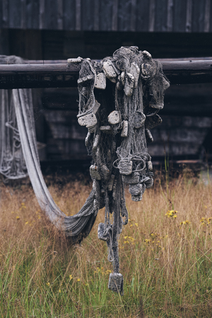 In Western Finland, an old fishing net is hanging on a fence. Matte styleの写真素材