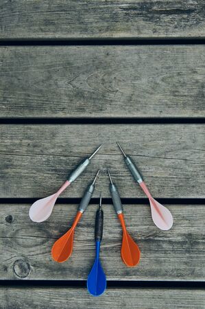 Multi-colored darts resting on wooden boards, fun for leisure.の写真素材