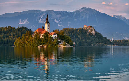 The enchanting church on the small island on Lake Bled in Slovenia, in the background the magnificent castle.のeditorial素材