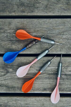 Multi-colored darts resting on wooden boards, fun for leisure.