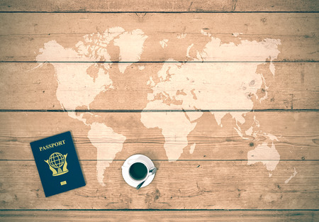 map of world on wooden background with a passport and a cup of coffee, concept of planning a travel (3d render)の写真素材