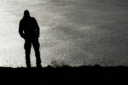 A silhouette of e man before the sea