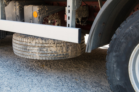 dirty truck spare tyre placed horizontally under cargo bed loading areaの写真素材