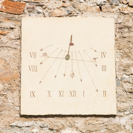 vertical sundial made of a carved stone's slab  and an iron rod