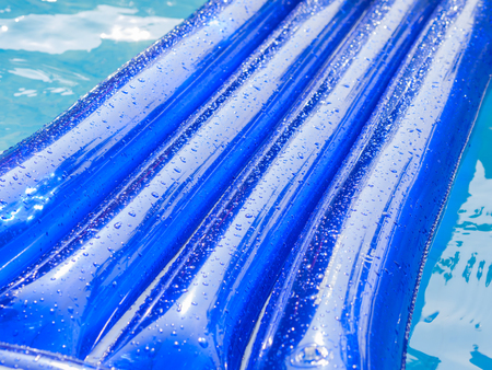 Detail of an  inflatable pad with water drops on the surface floats in a swimming poolの写真素材