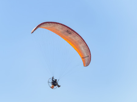 Forte dei Marmi, Italy _ April  29, 2017 Paramotor or Powered Paragliding: paraglider with small engine attached flying in blue sky
のeditorial素材