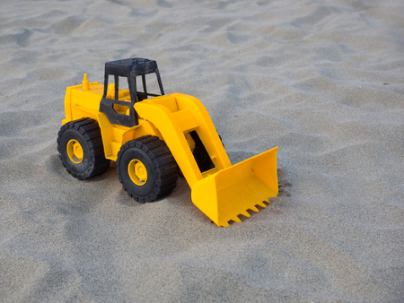 toy wheel loader excavator, contruction machine, on the sand at the beach