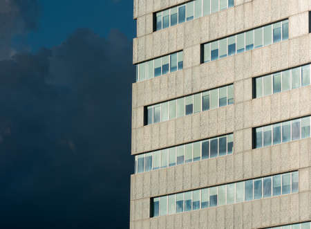 detail of a modern office building, dark blue cloudy sky in backround