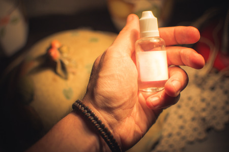 a hand holding a plastic bottle with a blank label