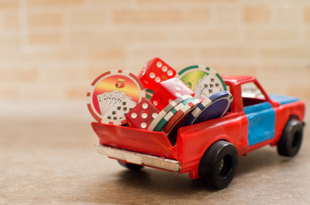 dice and casino tokens stacked on a toy carの写真素材